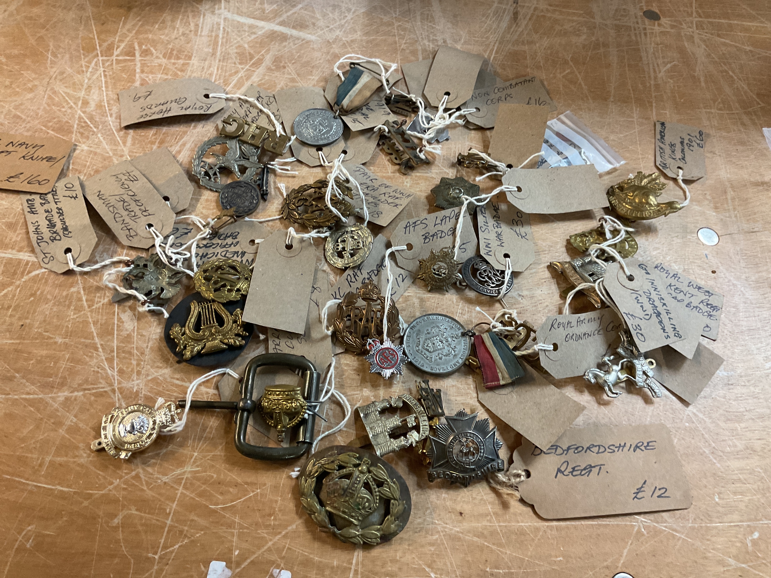 Large qty original cap badges and other insignia .