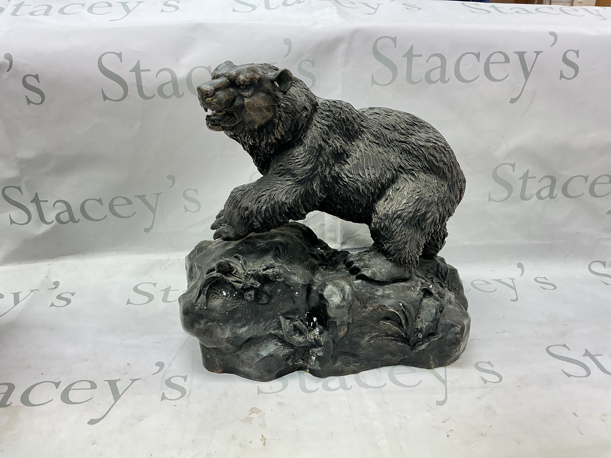 A cast bronze figure of a bear.