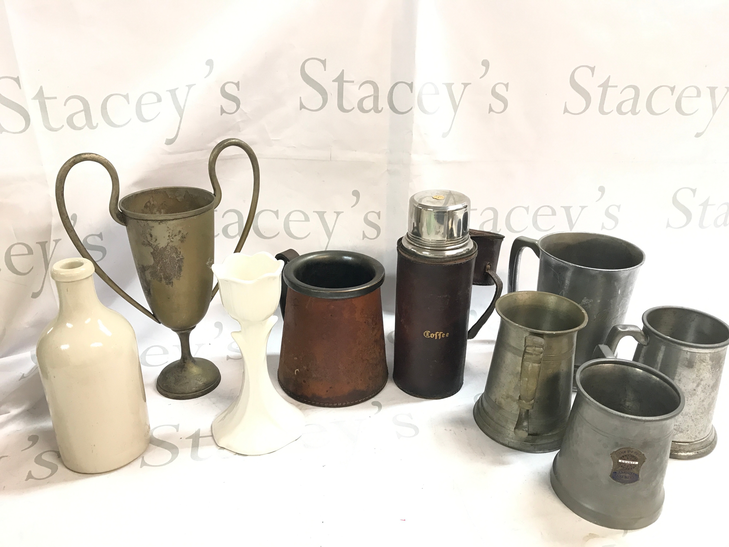 a collection of pewter teapots including a ceramic example, coffee canister with leather case 