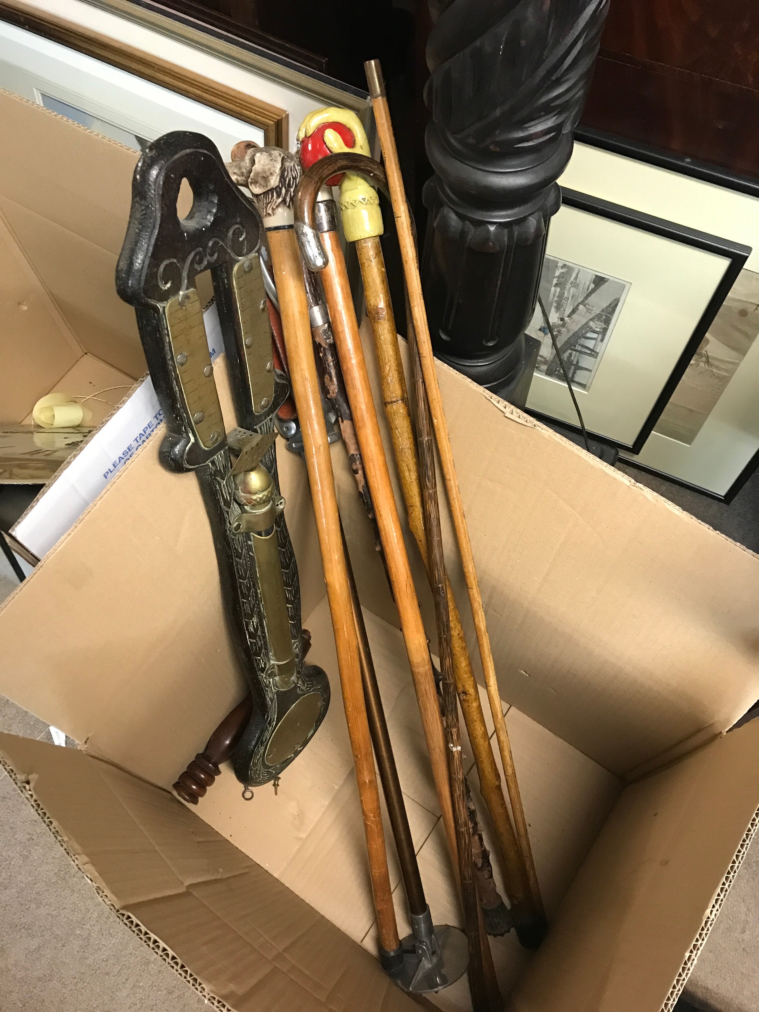 A collection of walking sticks and a retrospective copy of a water barometer