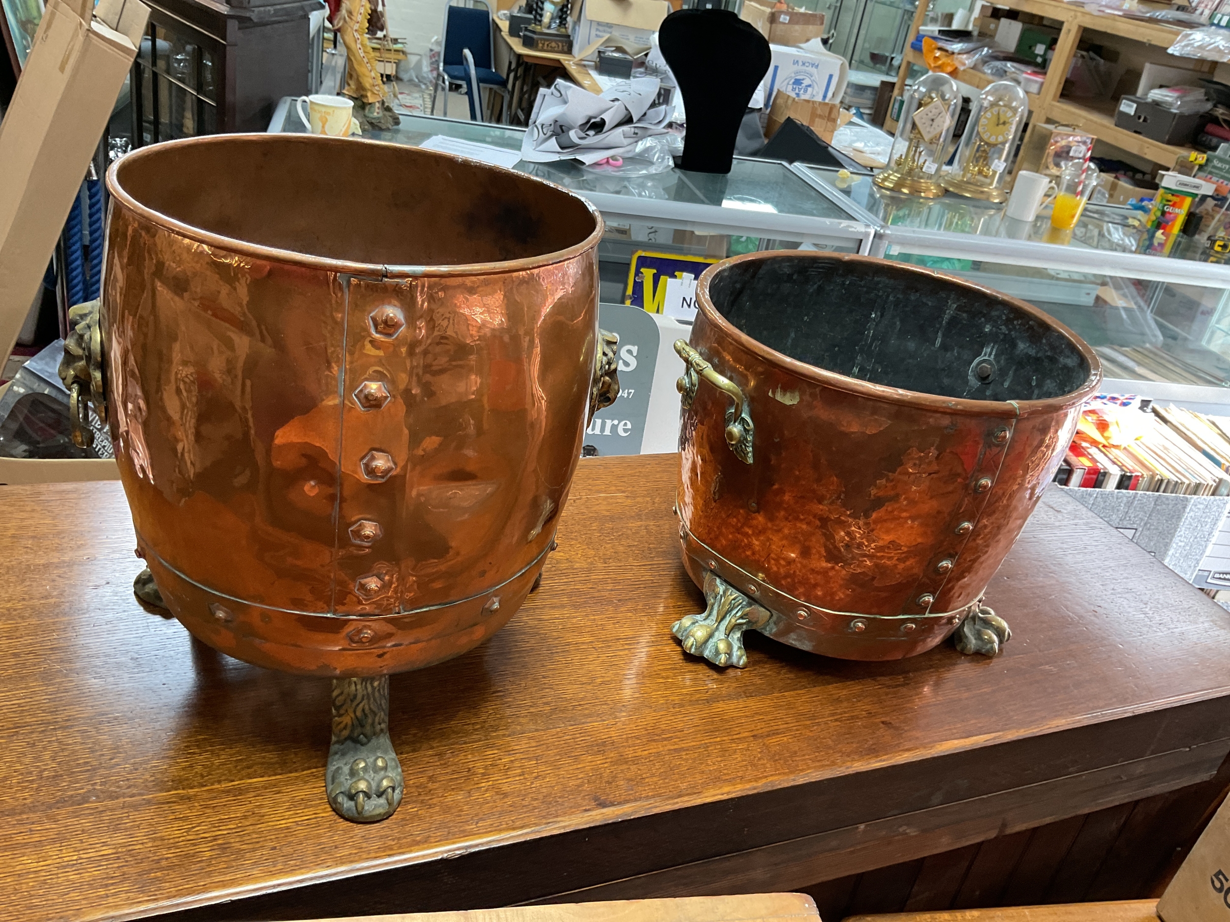 Two copper and brass scuttles on lion claw feet.