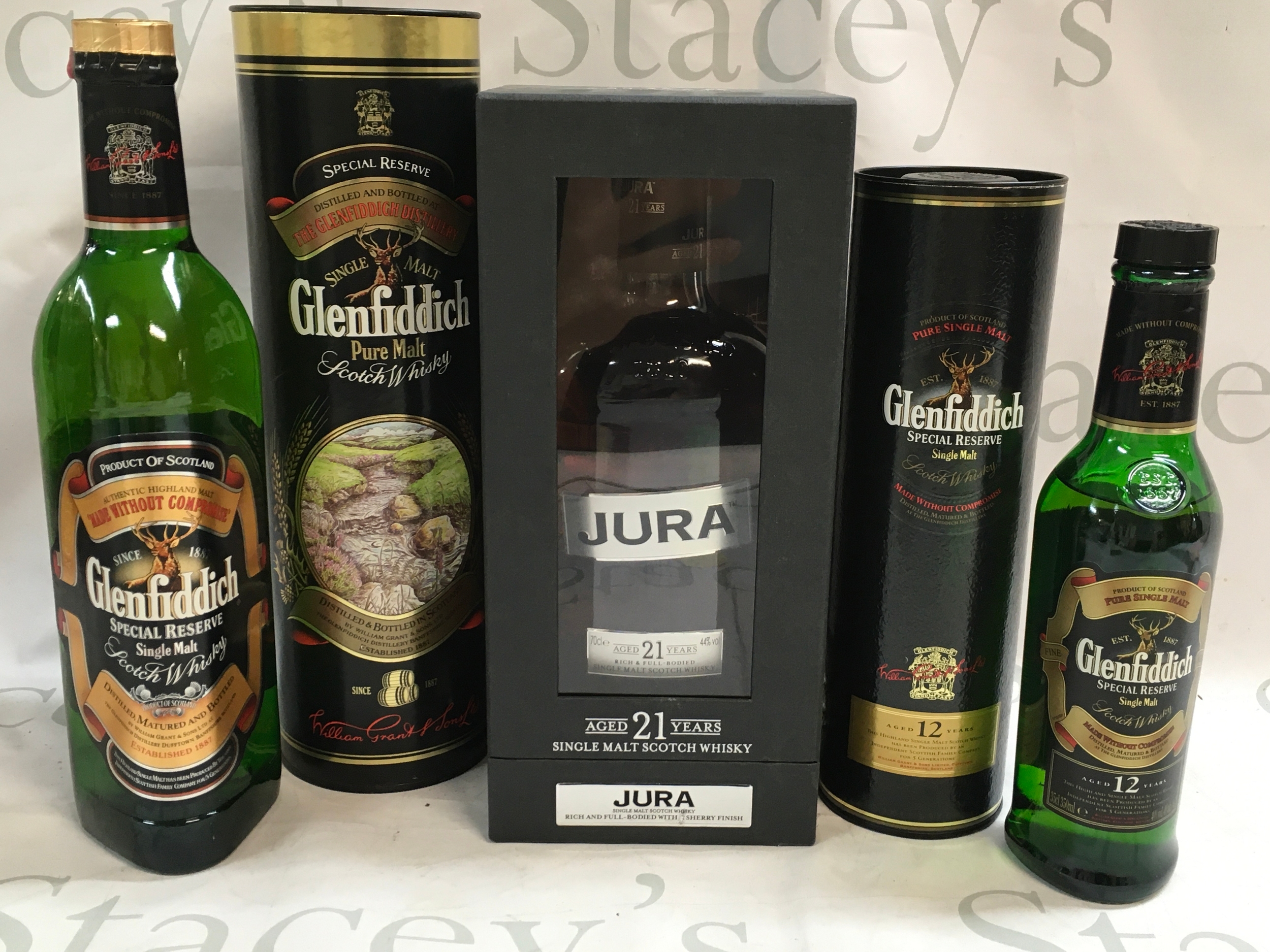 Three single malt Scotch whiskies. Two Glenfiddich bottles, one is a 12 year aged 35cl bottle and the other a special reserve 75cl bottle. The third a 21 year aged Jura single malt 70cl bottle. 