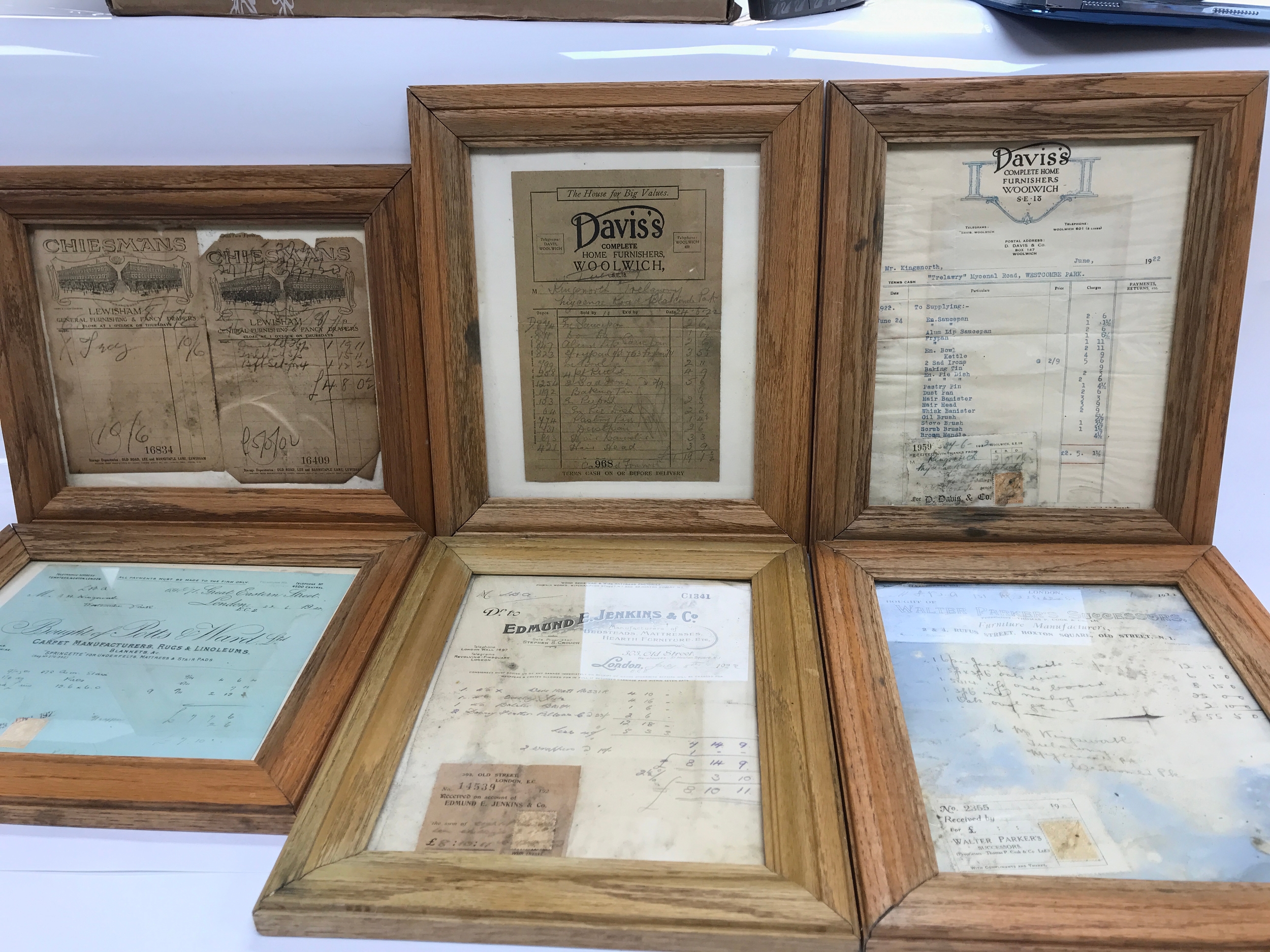 Antique framed paper ephemera items, including old tradesmen's bills, invoices, and receipts from businesses such as "Chiesmans" and "Davis's Complete Home Furnishers, Woolwich" housed