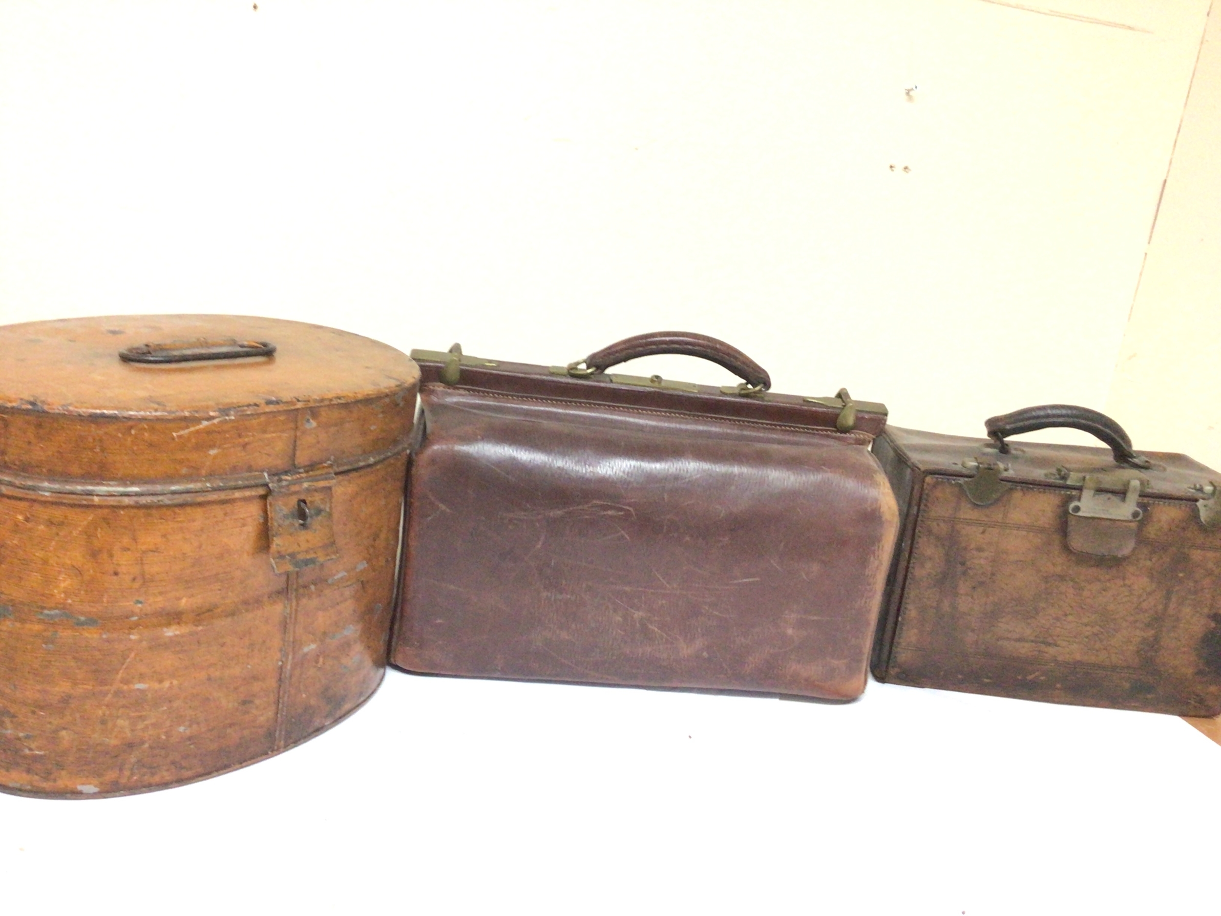A Vintage leather Gladstone bag one other Vintage leather case and a Victorian tin hatbox. (3) NO RESERVE