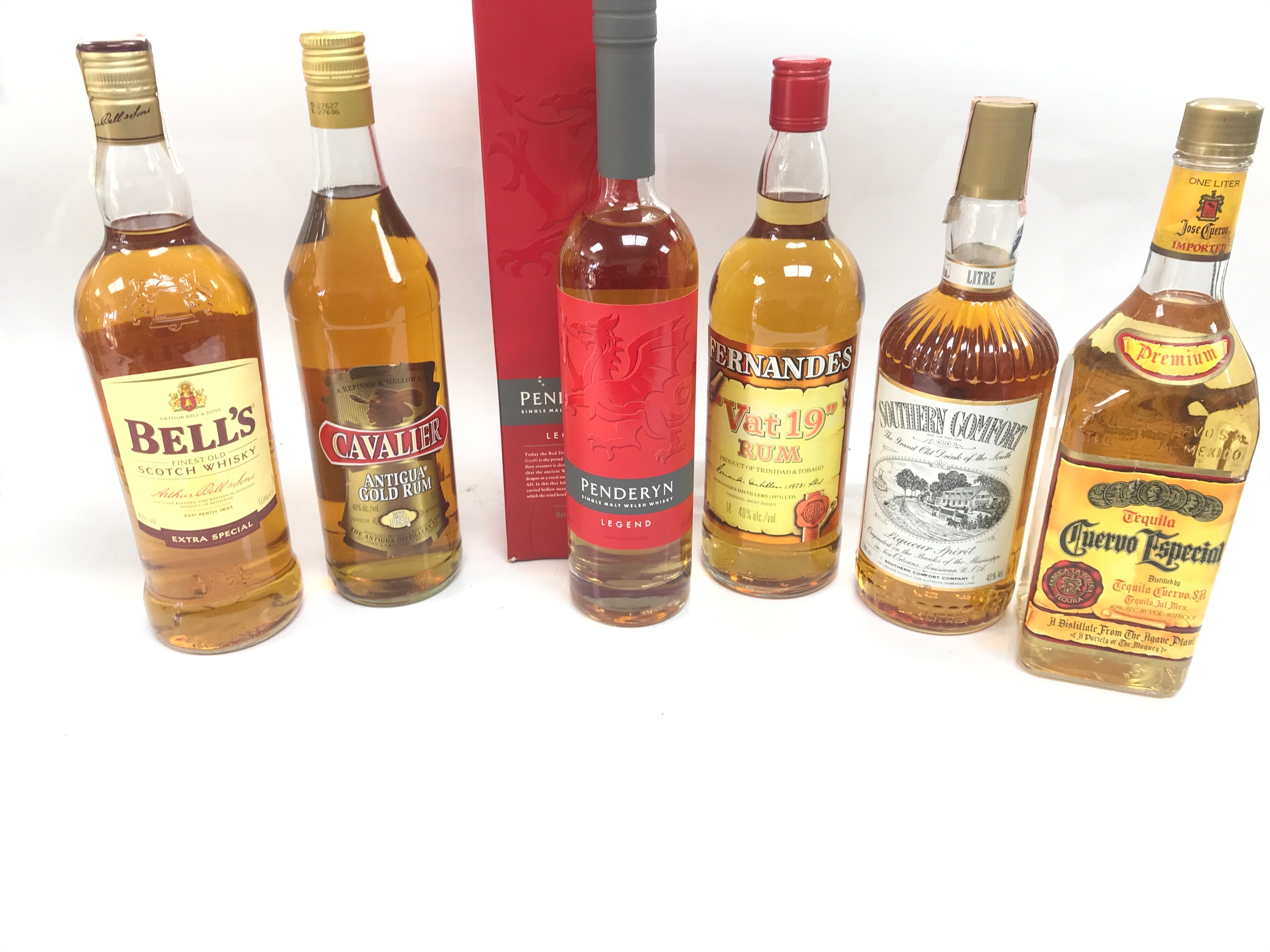 Quantity of whiskey and rum and other bottles. 1 litre of bell's Scottish whiskey 1 litre of Antigua gold rum Penderyn single malt Welsh whisky 1 litre of 'Vat 19' Rum 1 litre of southern comfort 1 litre of Cuervo Especial tequila