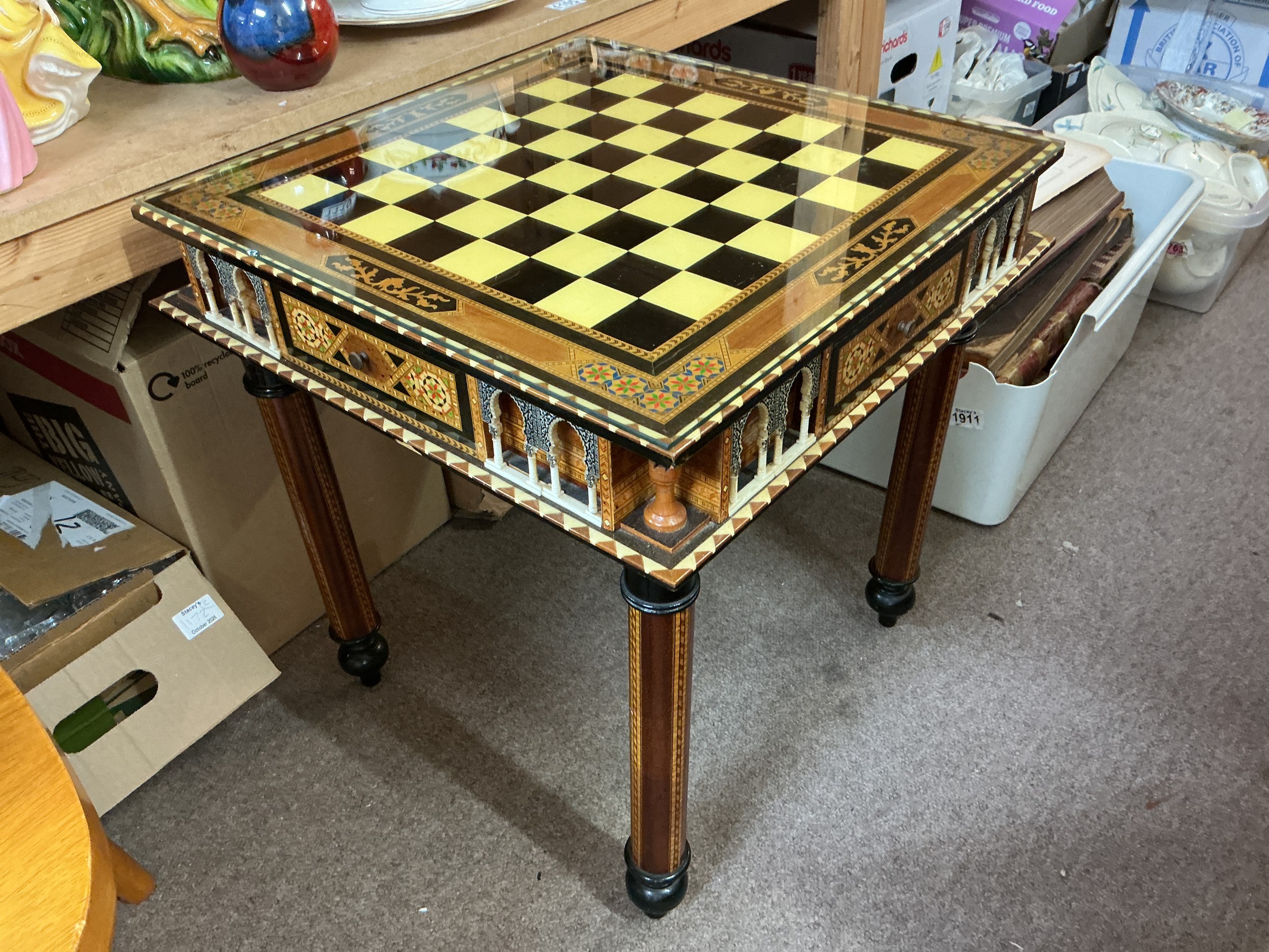 A modern chess table with chess set pieces of classical Trojan figures.