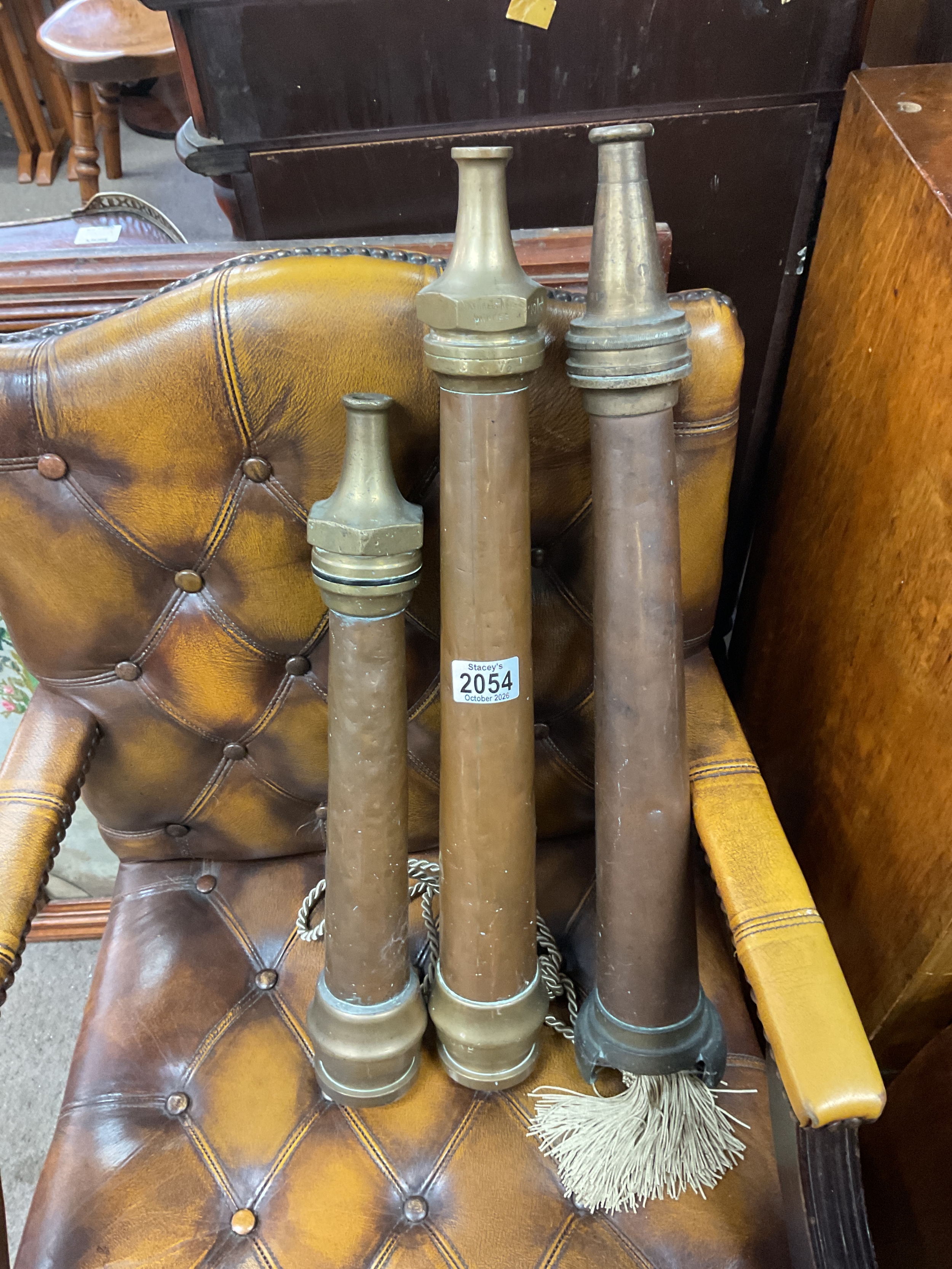 Three vintage copper and brass fireman's hose branches.