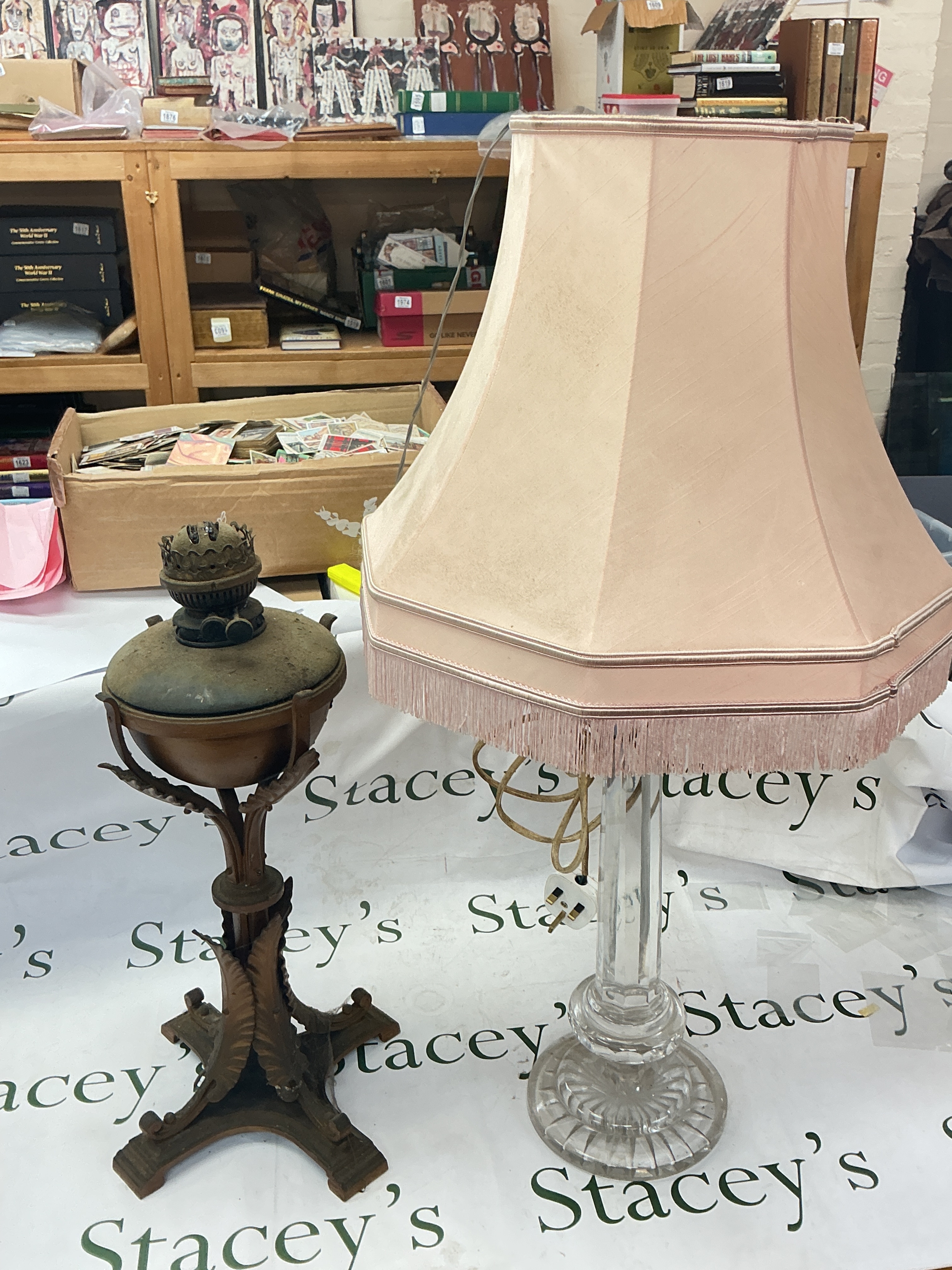 Art Nouveau copper and cast iron table oil lamp and a vintage clear glass stick table lamp. 55 and 82cm tall 