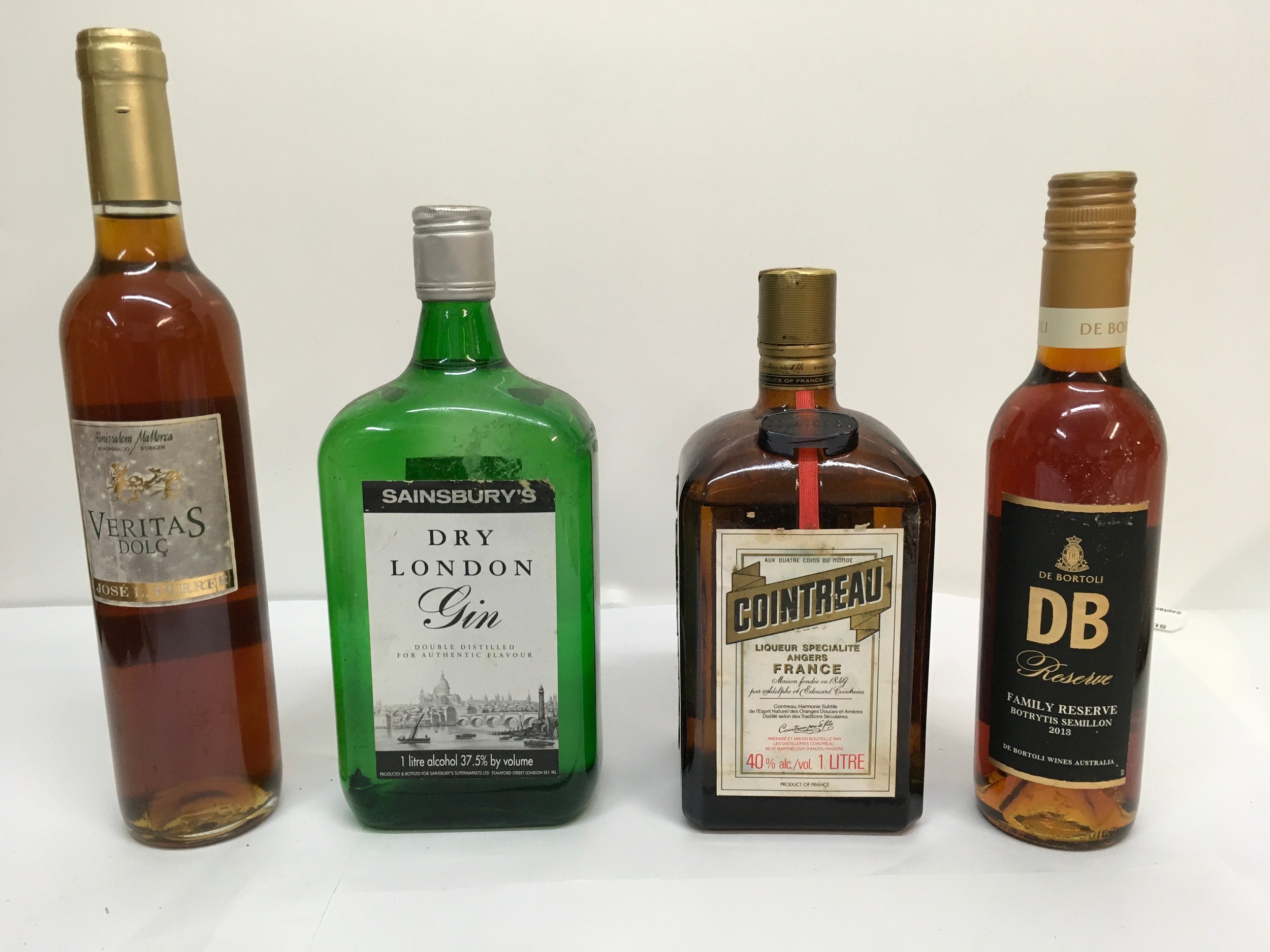 Four bottles of alcohol comprising Cointreau, dry gin, Veritas Dolc and DB reserve wine