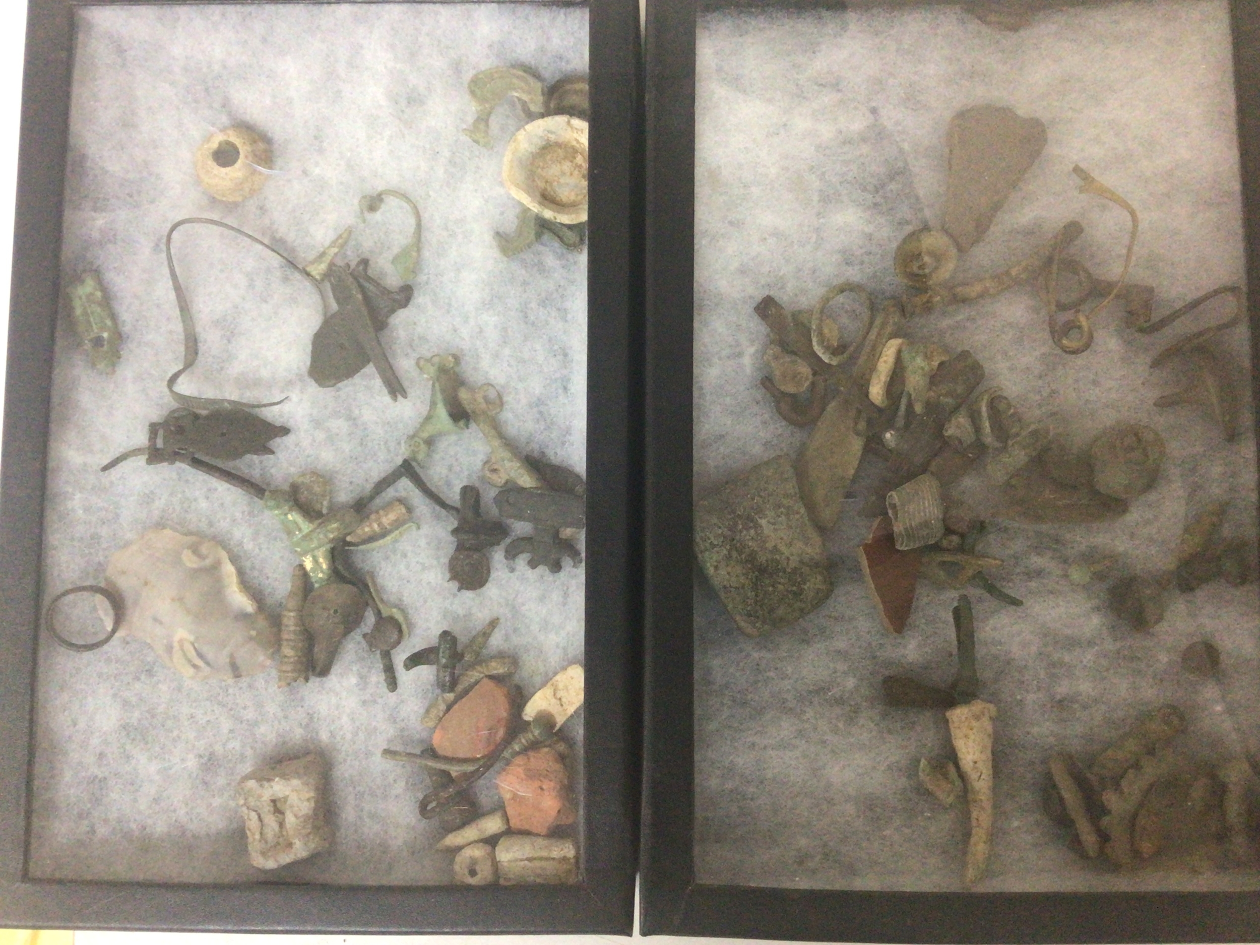  A collection of ancient metal detectors finds in two open cases 