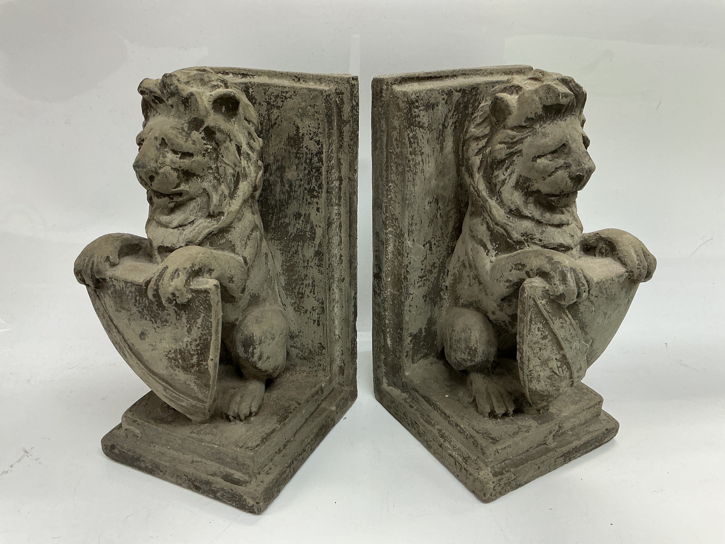 A pair of bookends in the form of lions with shields, approx height 21.5cm.