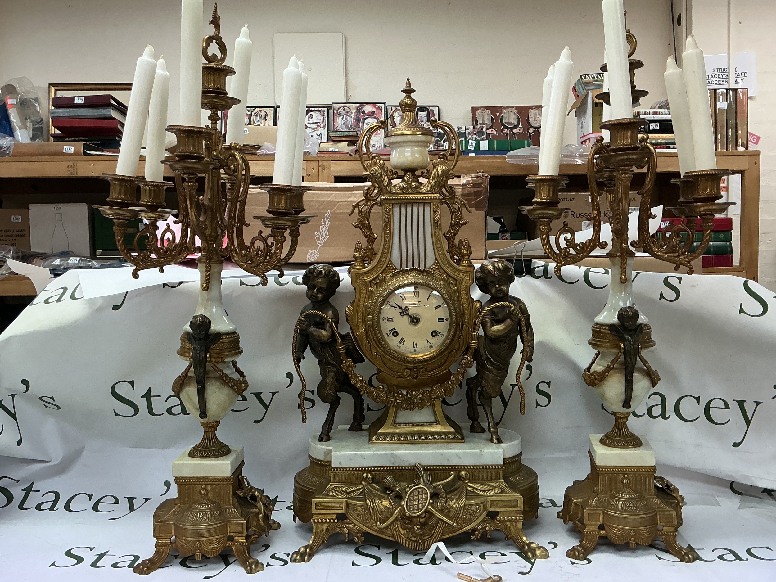 An Italian style gilt bronze and marble mantel clock and candelabra garniture set. 60 and 68m tall