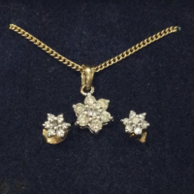 A 9ct gold diamond pendant on 9ct chain with matching earrings.