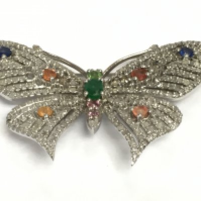 A stylish silver butterfly brooch/pendant set with emeralds, vari coloured sapphires and several diamonds. Diamonds approx 1.86ct, sapphires approx 1.21ct, emeralds approx 0.20ct. Approx width 5.5cm. Shipping category A.