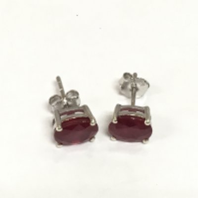 A pair of treated ruby studs in silver. Shipping category A.