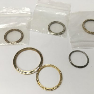 A collection of rolex style bezels including diamond set.