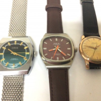 A vintage Oris wrist watch with orange second hand seen working one other Oris watch with a Chrome strap and a Nivada watch (3)