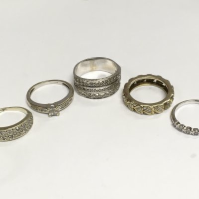 Five assorted and unmarked rings, four set with diamonds, one CZ. Total approx 16.7g. Shipping category A.