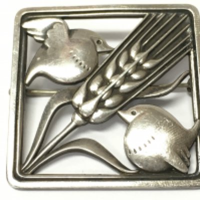 A Sterling Silver George Jensen brooch, two birds on either side of a head of barley . 4cm wide .Postage category A