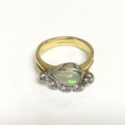 An 18ct gold ring inset with an opal and five diamonds, approx 8.8g and approx size P-Q. Shipping category A.