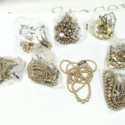 A Collection of simulated pearl necklaces . Postage category A