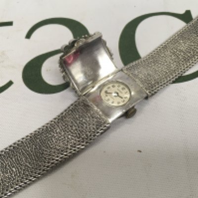 A silver cased designer ergo watch with a flip patterned cover.