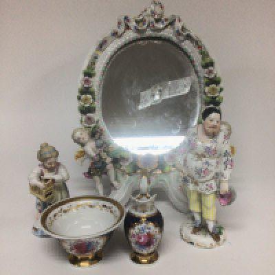 A late 19th Century porcelain mirror decorated with raised flowers and putti a miniature Chamberlain Worcester hand painted jug and bowl and two German porcelain figures. (some damage)