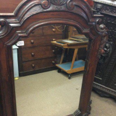 A carved wall mirror of arched shape 120 cm x 80 cm