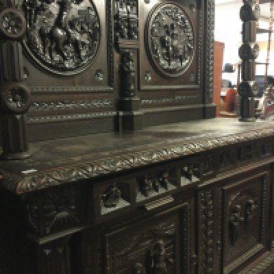 A large oak sideboard profusely carved with figures horses flower heads And foliage the raised back above two drawers and cupboards under on claw feet .245 cm x 180 cm .