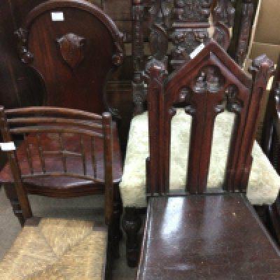 A collection of furniture including four chairs including two hall chairs and a folding table with brass tray top .
