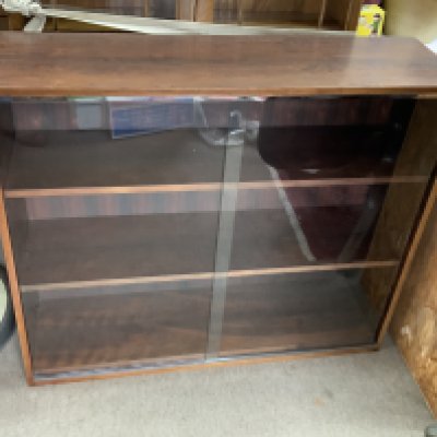 A Mid century Rosewood veneered bookcase with glazed sliding doors. 106cm x 90cm x 31cm