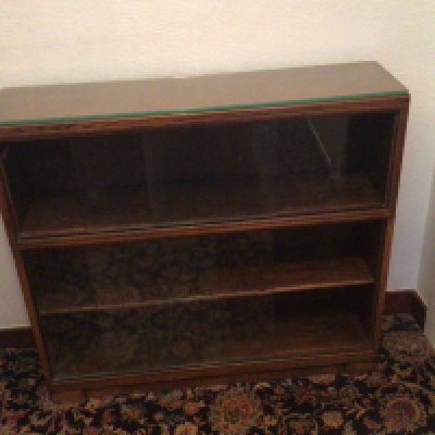 A Mahogany bookcase with glass sliding doors.