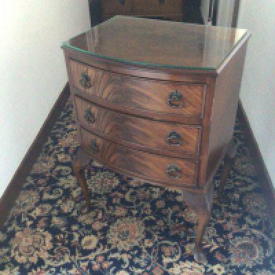 An inlaid wall mirror of rectangular shape and a small mahogany chest of drawers with cabriole legs.