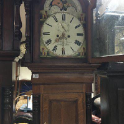 A oak long case clock the Arched painted dial with Roman numerals.