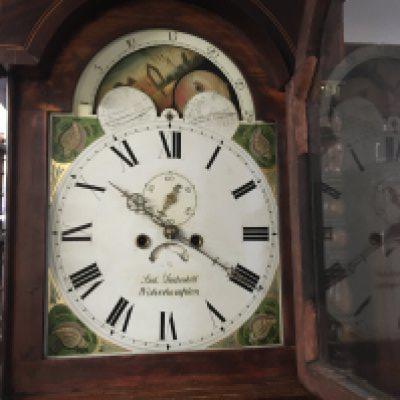 A oak long case clock the arched panted dial with moon roller Roman numerals and second dial .
