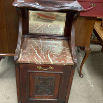 a mahogany drop front coal box cabinet with red marble top.
