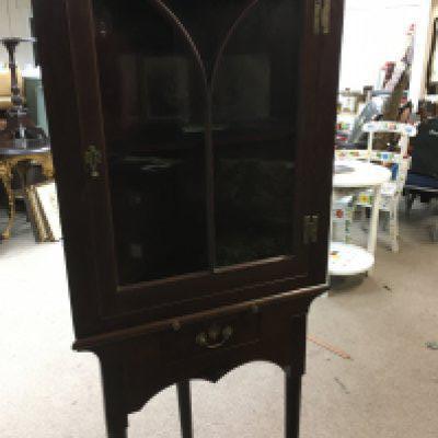 A Mahogany corner cabinet with single drawer on cabriole legs and pad feet .