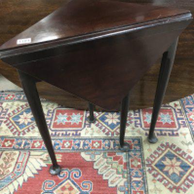 A unusual Georgian mahogany table with single flap the shape top with a enclosed compartment on square tapering legs and pad feet .