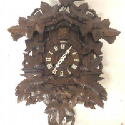 A Black forest carved wood cuckoo wall clock with applied and carved foliage. 70cm top to base