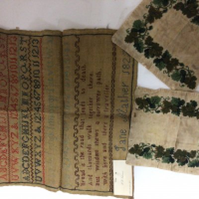 An Early 19th century needlepoint embroidery by Jane Mather 1827 two rows of alphabet above a verse and two other embroidered silk fragments (3)