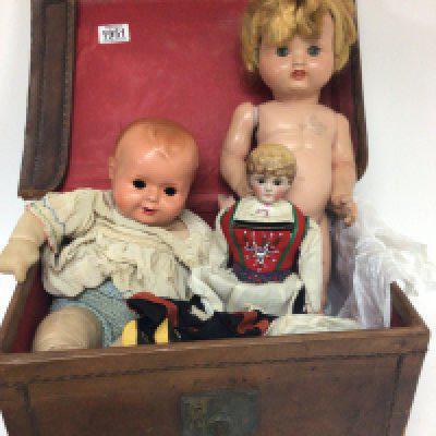 A Vintage leather case containing a Norwegian doll in traditional dress and two other composition dolls.