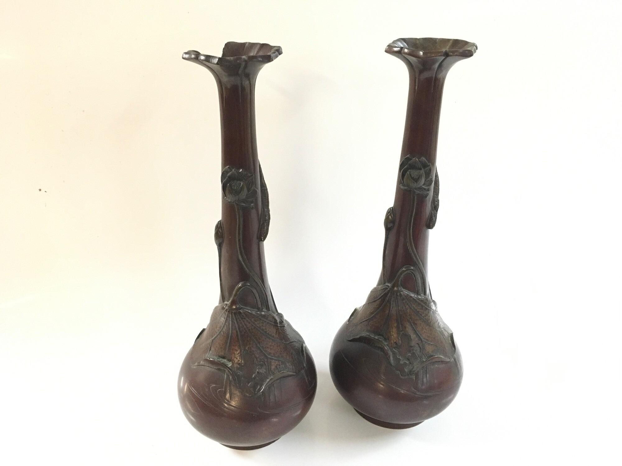 A pair of Japanese bronze vases, some damage, 29cm tall. Decorated with leaves and flowers.