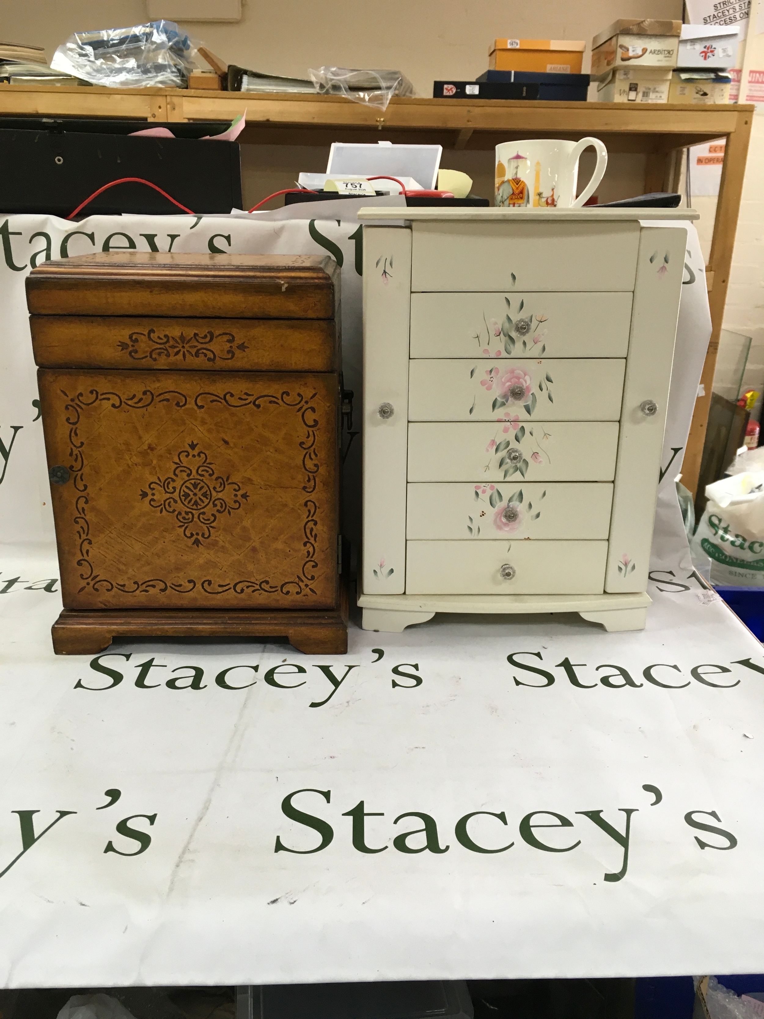 A white jewellery cabinet with a cream finish and hand painted pink floral designs. Which includes some jewellery. 
A handmade tole painted jewellery drawer box. 