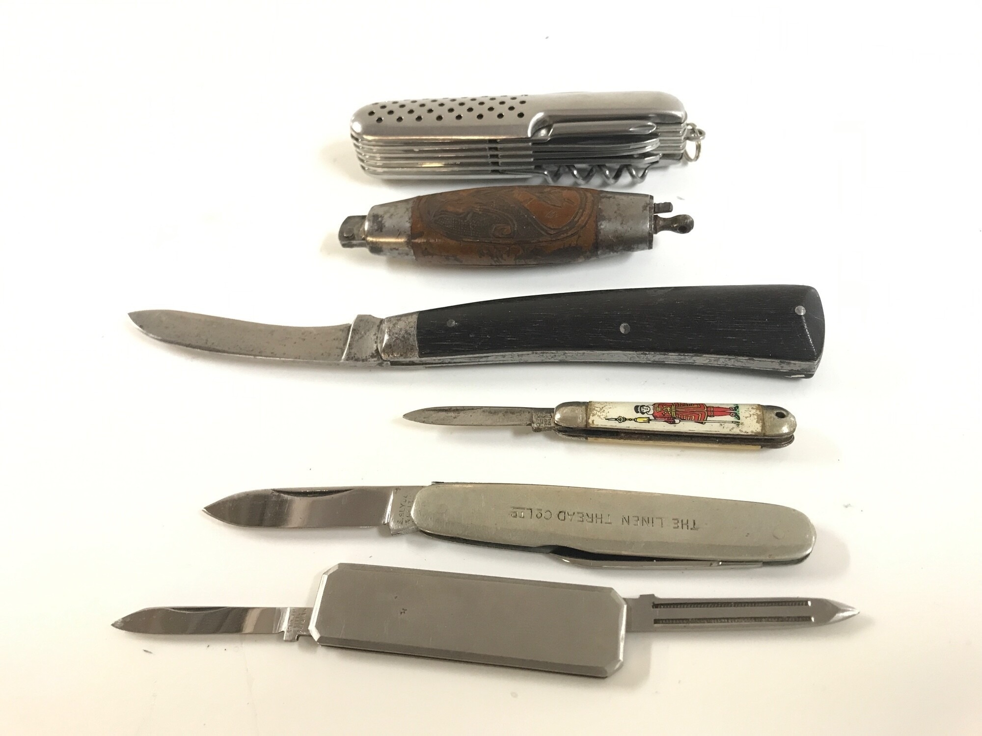 A collection of penknives to include a barrel knife with carved body, Saynor folding knife, Advertising knife for the Linen Thread Co. Ltd. Etc,, NO RESERVE