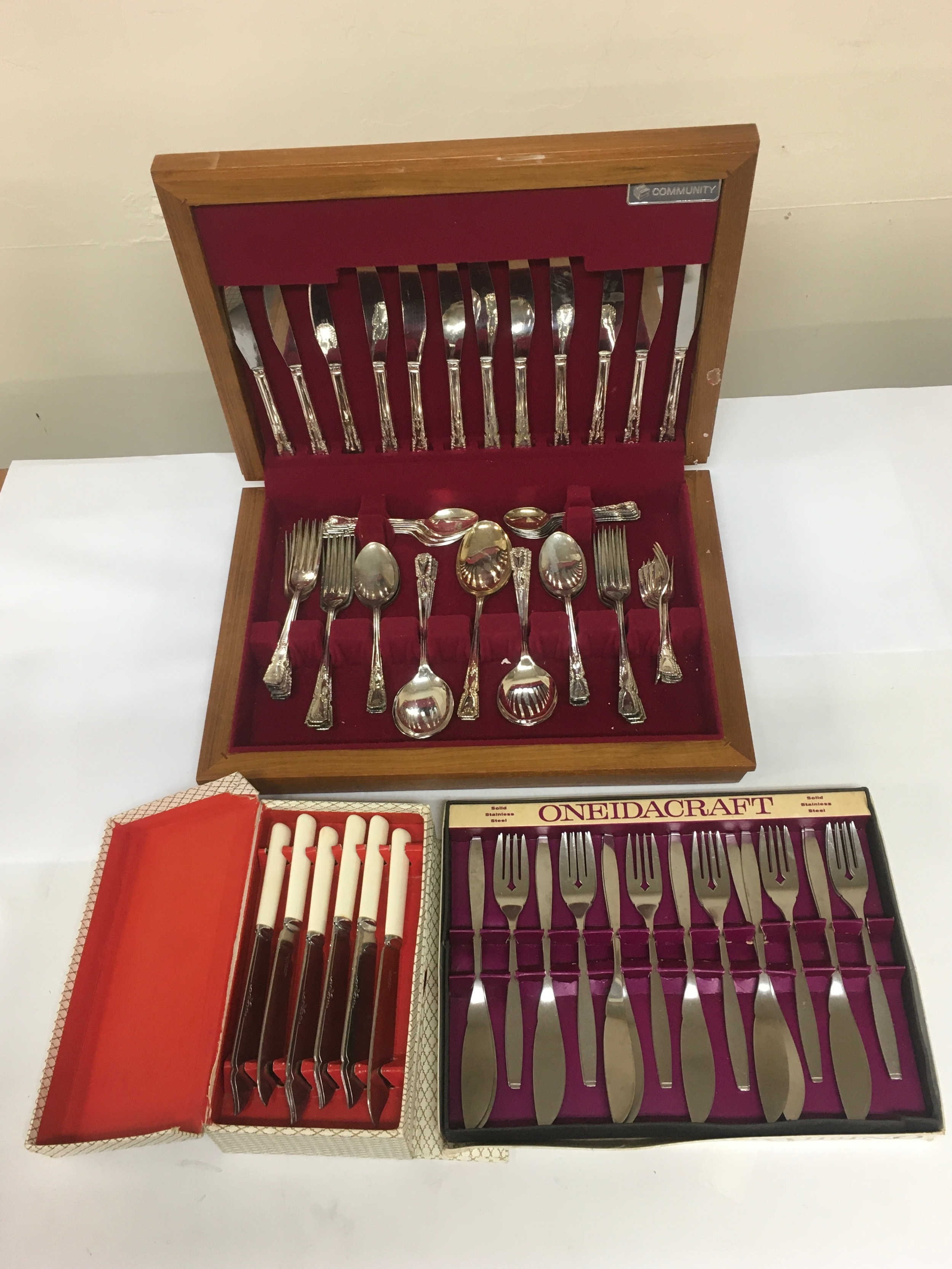 3  sets of stainless steel cutlery with Cases/ boxes. 2 are marked stainless Sheffield steel.