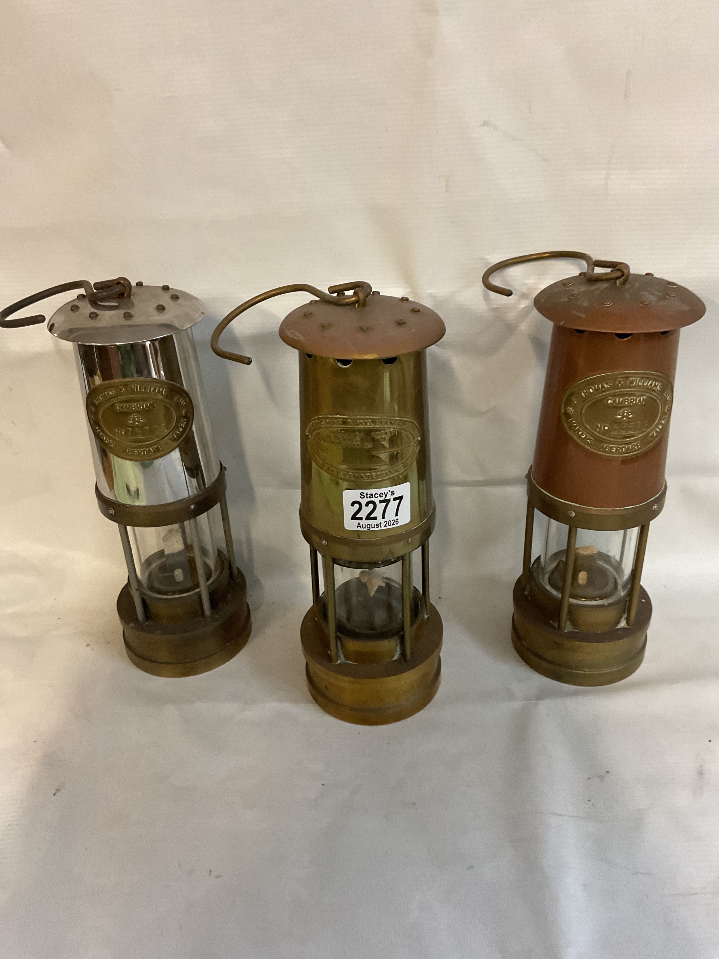 Three vintage miners lamps, two from Cumbria.