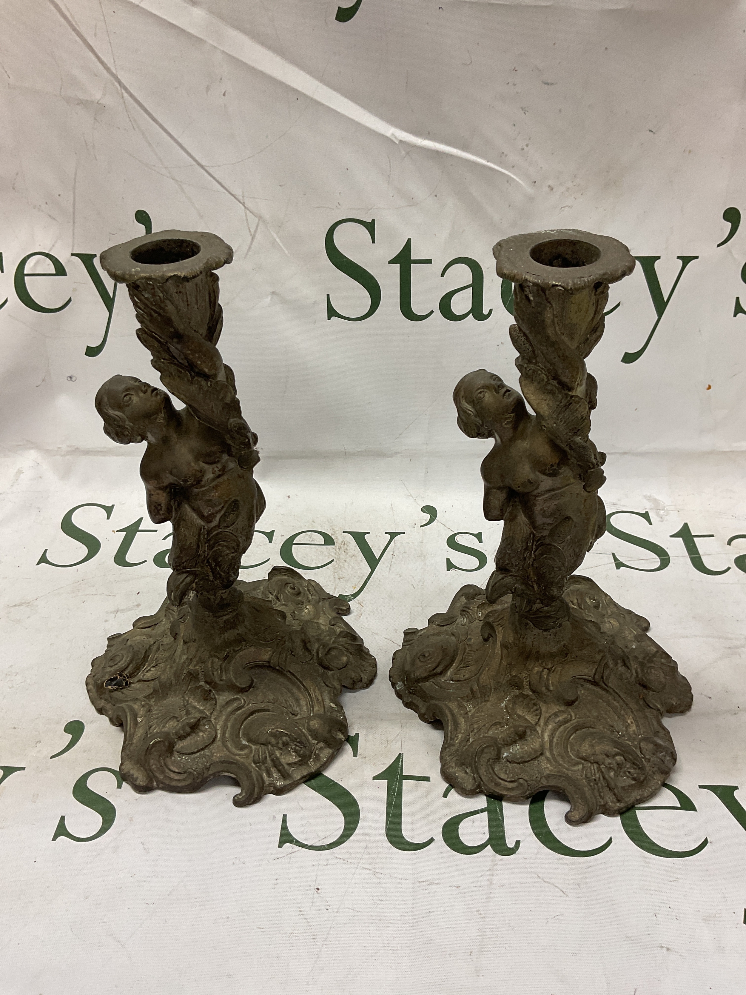Pair 19th C heavy cast candlesticks, modelled as a leaping mermaids/nymph and the base decorated with shells, waves, dolphins and crustaceans. H 24 cm.