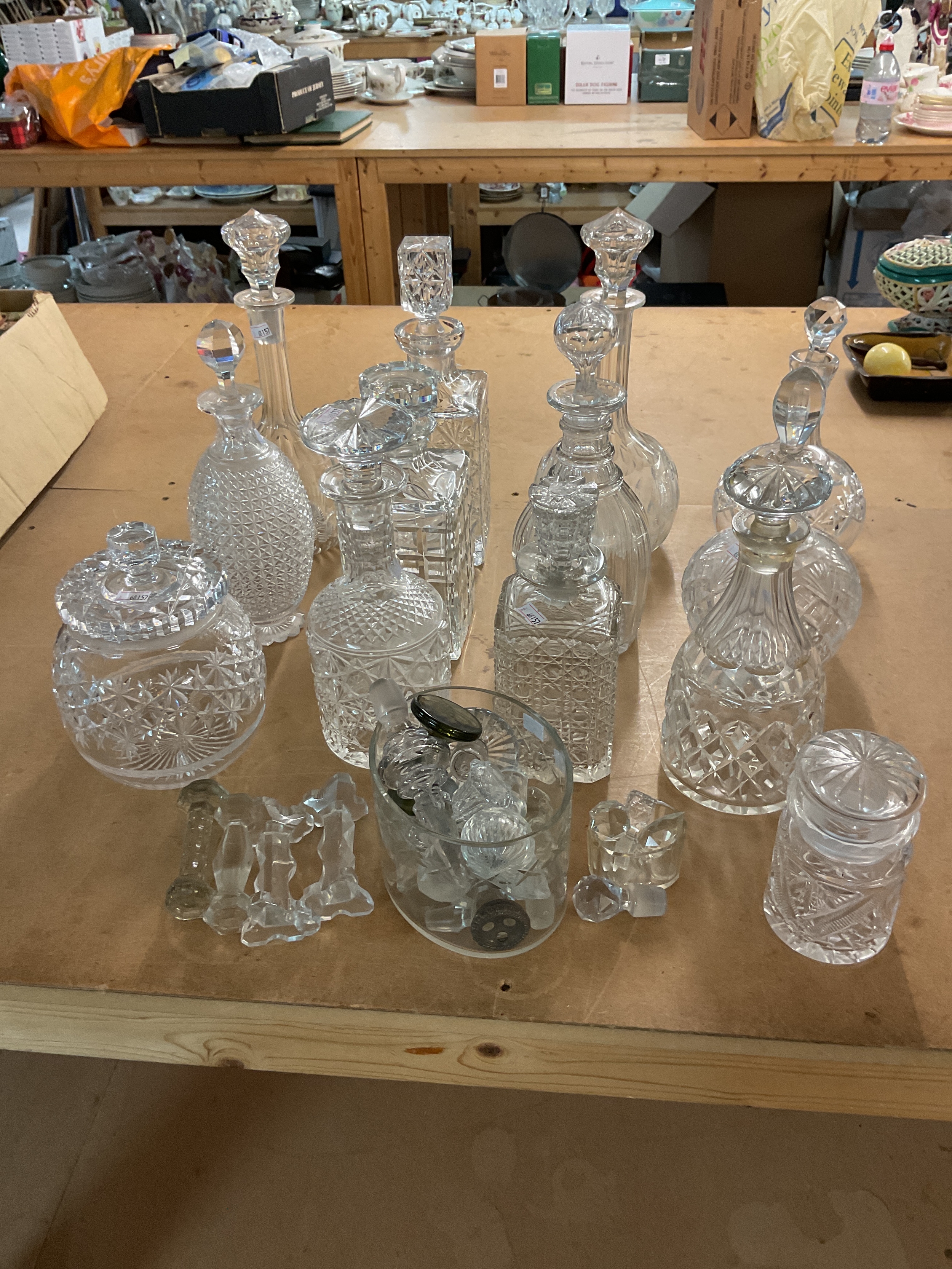 Eleven decanters along with other glass ware and extra stoppers and four knife rests.