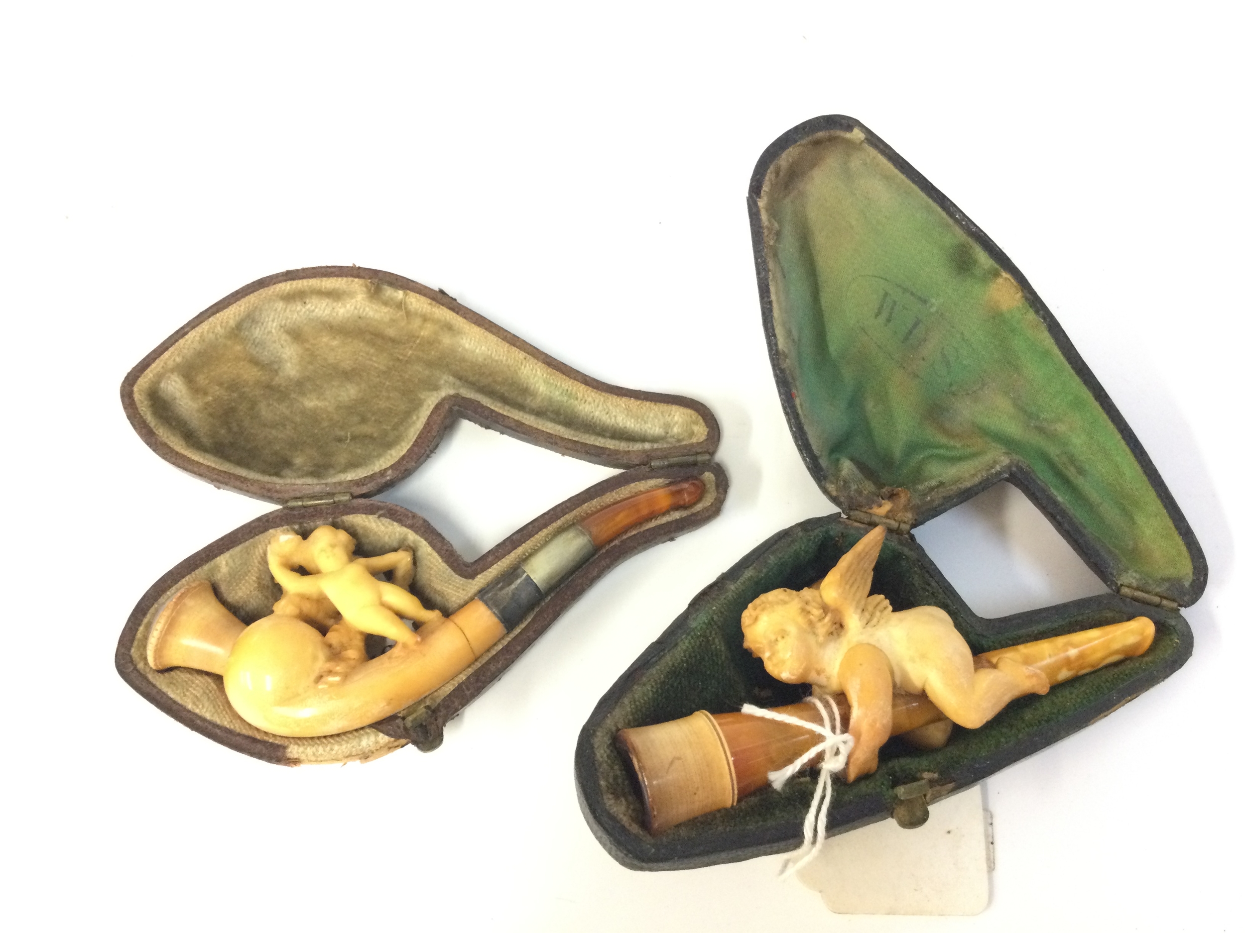 Two cased cherub meerschaum tobacco pipes, 9 and 9.5cm long 