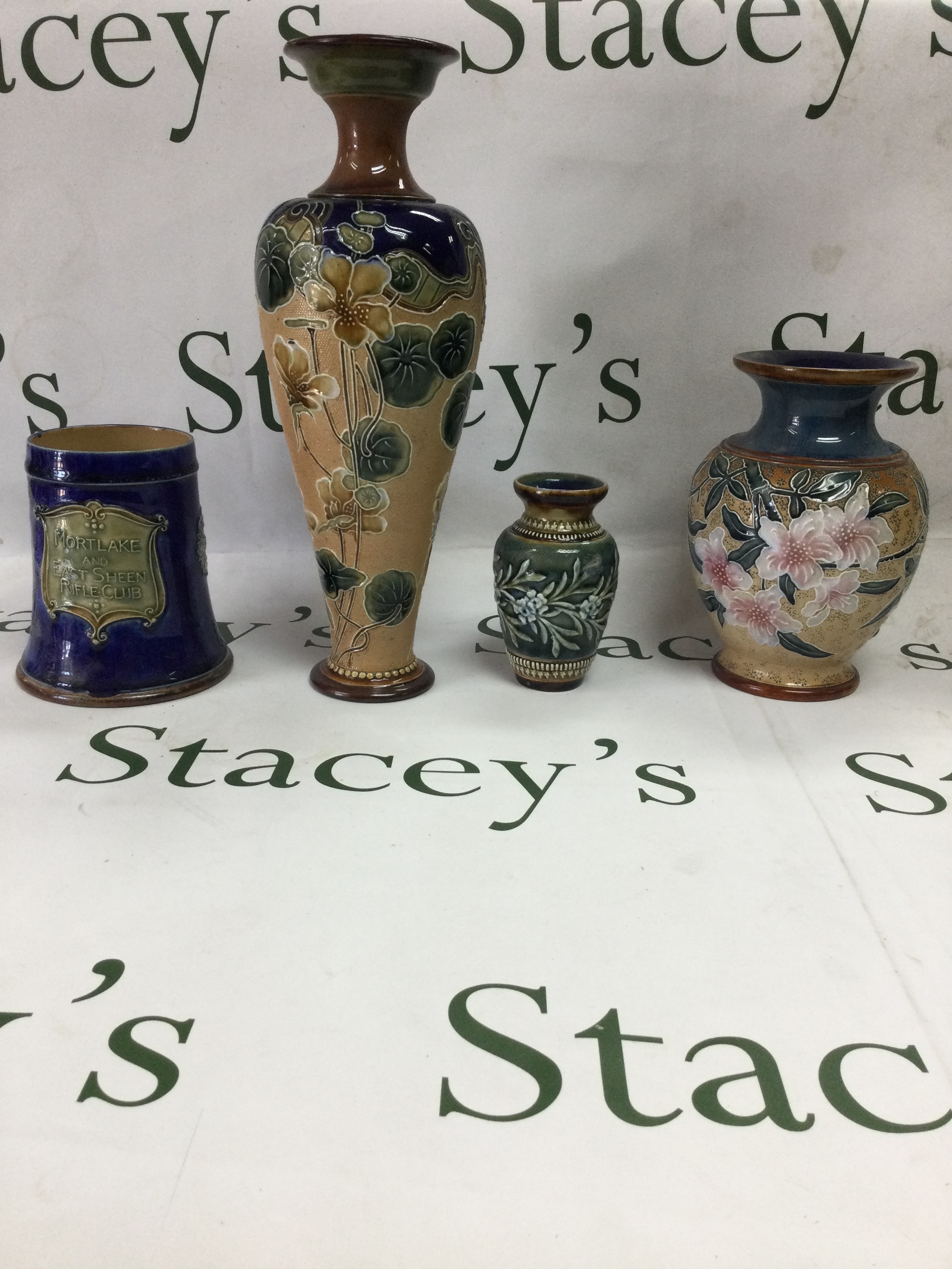 Collection of Doulton and stoneware four pieces of antique English art stoneware, all Doulton. Including a tankard, tall slender vase, baluster vase and a small relief-decorative vas.